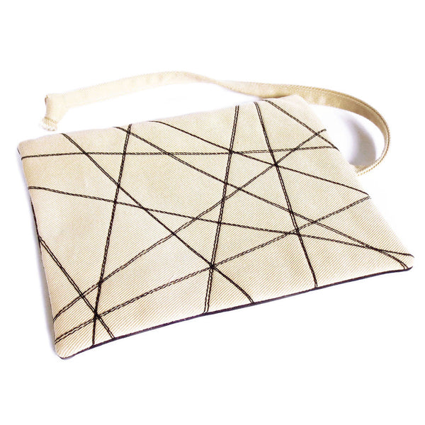 fabric watch roll with abstract design in black stitching on off-white denim
